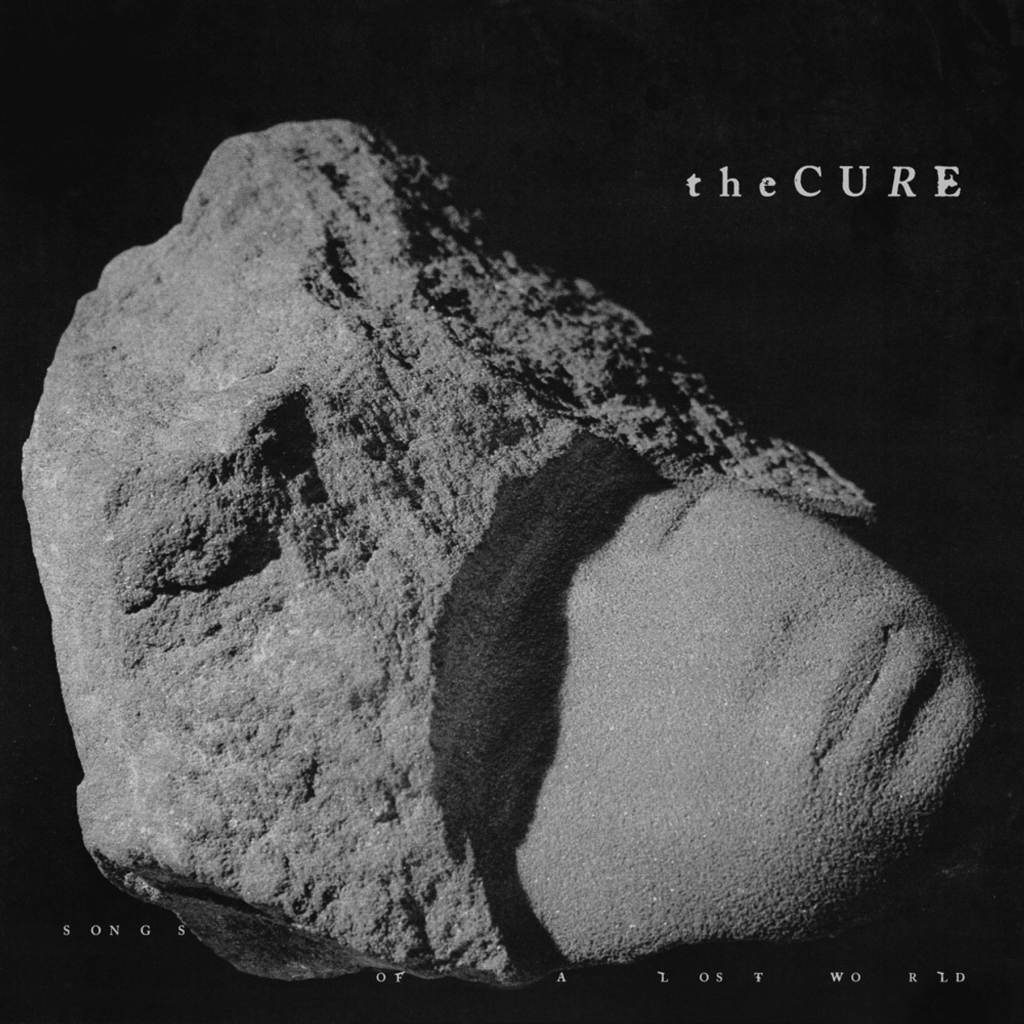 Black and white image of a rock with text "the CURE" and "SONGS OF A LOST WORLD" overlaying.